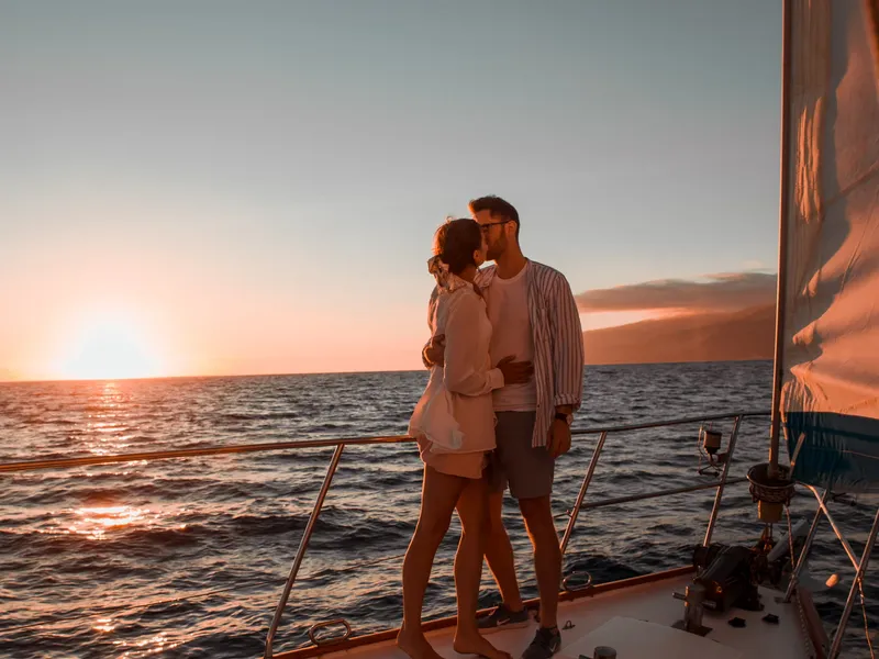 A couple embracing on the foredeck at sunset